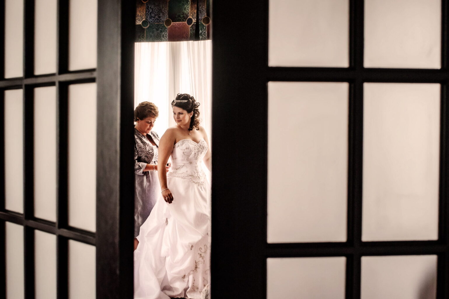 Halifax wedding photographer capturing mother helping bride into dress on wedding day