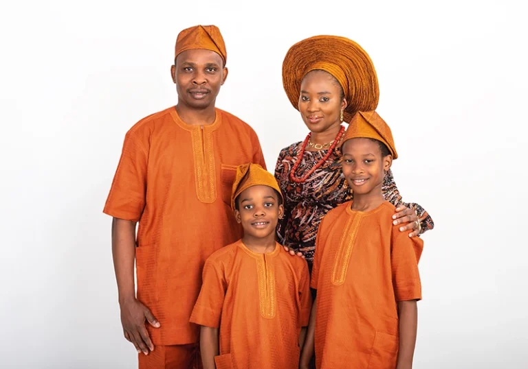 Mother and father posing with their two boys, all dressed in traditional African attire, captured in a Family Portrait Studio in a joyful and cultural family moment.