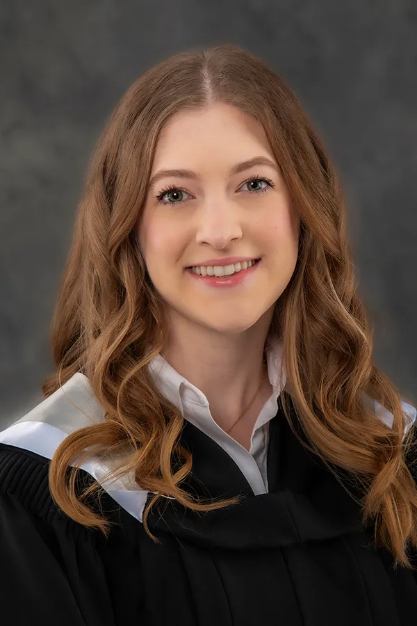 International student at Dalhousie University celebrating graduation in official gown and hood on the Halifax campus.