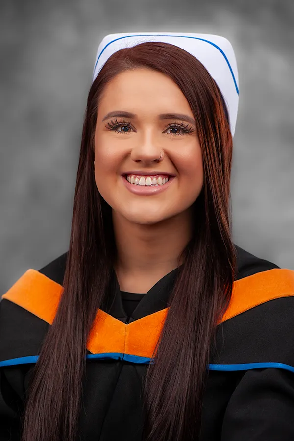 St. Francis Xavier University graduate in a professional studio portrait with official academic hood.