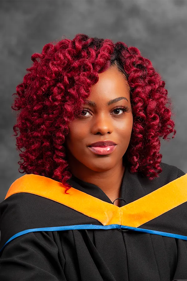 St. Francis Xavier University graduate in official blue and yellow regalia showcasing her X-Ring.